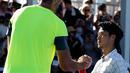 Petenis Kroasia, Ivo Karlovic dan petenis Jepang, Yuichi Sugita bersalaman seusai babak kedua turnamen Australia Terbuka 2018, Rabu (17/1). Memasuki usia 40 tahun, Karlovic memenangi duel dengan skor 7-6 (3), 6-7 (3), 7-5, 4-6, 12-10. (AP/Ng Han Guan)