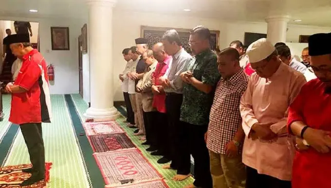 Najib Razak dan istrinya, Rosmah Mansor, bersama simpatisan dan termasuk para politikus Umno, salat berjamaah di rumah dinas Taman Duta. (Facebook)