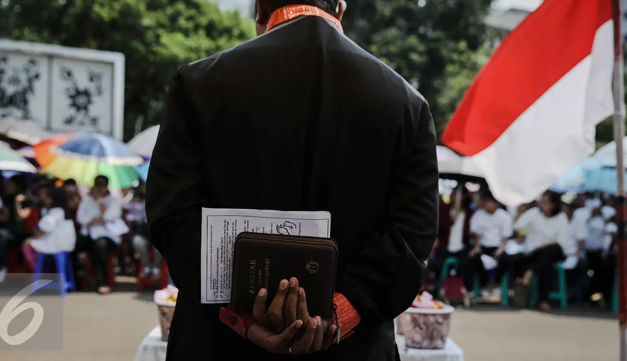 Seorang pendeta memimpin pelaksanakan ibadah peringati hari Paskah di depan Istana Negara, Jakarta, Minggu (27/3/2016). Mereka meminta pemerintah untuk memberikan solusi bagi permasalahan tempat ibadah mereka. (Liputan6.com/Faizal Fanani)