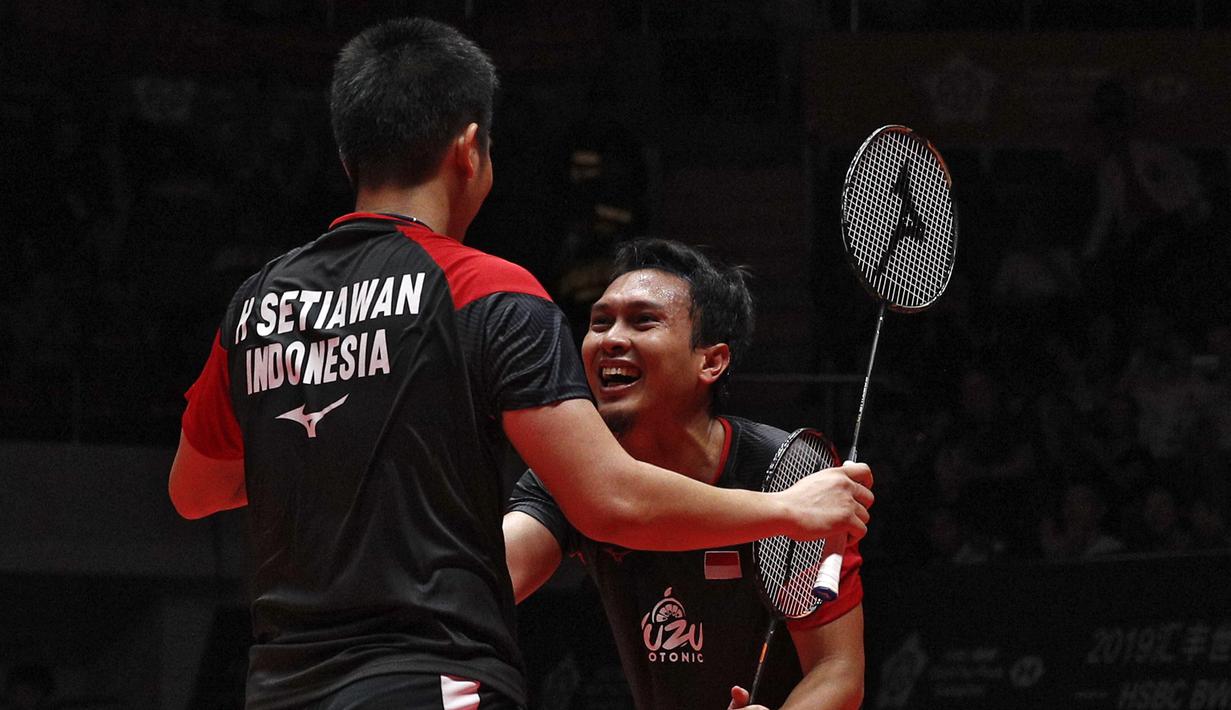 Ganda putra Indonesia  Mohammad Ahsan/Hendra Setiawan berselebrasi usai mengalahkan Hiroyuki Endo/Yuta Watanabe dari Jepang pada final BWF World Tour Finals 2019 di Tianhe Gymnasium, Guangzhou (15/12/2019).  Indonesia sukses membawa pulang satu gelar juara melalui Hendra/Ahsan.  (AP Photo/Andy Wong)
