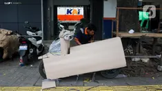 Pekerja mengemas motor untuk dikirim melalui salah satu jasa pengiriman logistik di kawasan Pasar Senen, Jakarta, Minggu (23/3/2025). (Liputan6.com/Herman Zakharia)