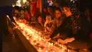 Umat Sikh menyalakan lampu tanah di Kuil Emas yang diterangi pada peringatan kelahiran Guru Nanak di Amritsar, India, 19 November 2021. Guru Nanak adalah Guru Sikh pertama dan pendiri Sikhisme. (AP Photo/Prabhjot Gill)
