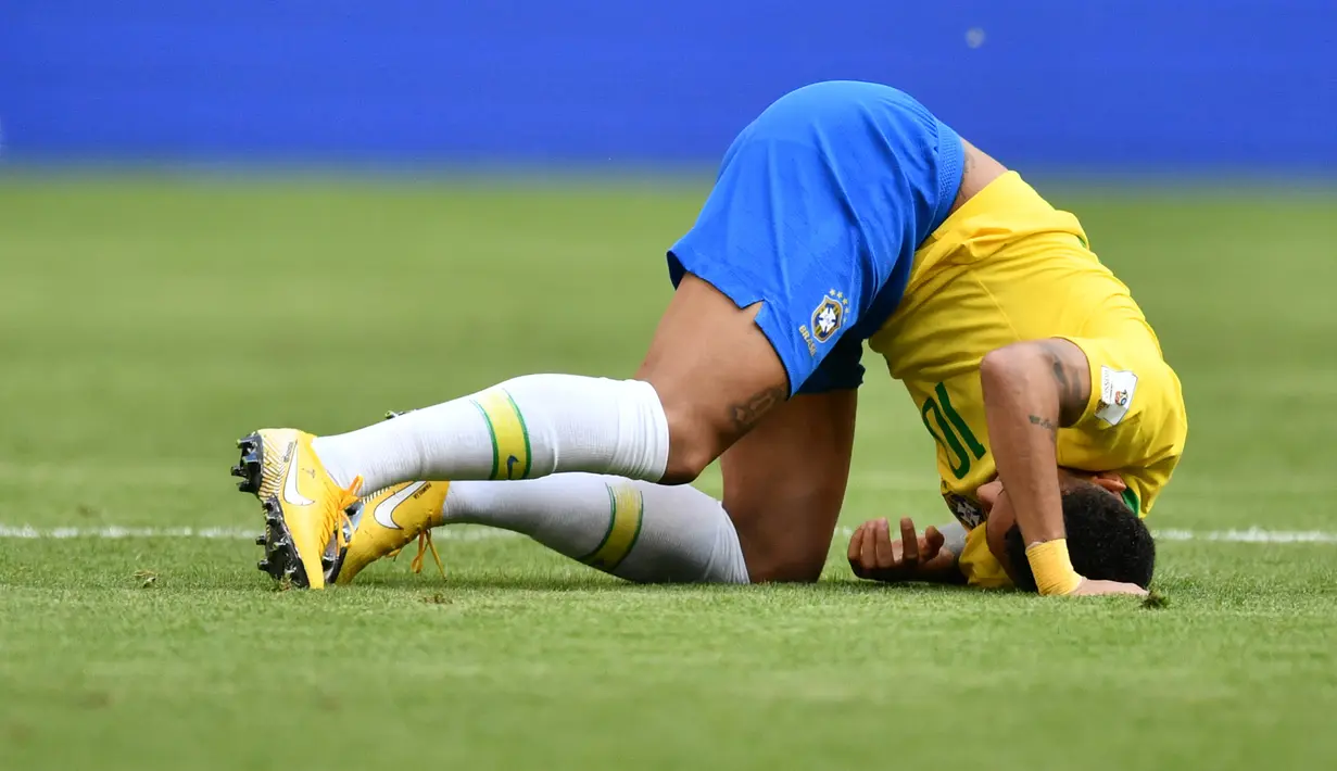 Penyerang timnas Brasil, Neymar berguling di atas lapangan pada babak 16 besar Piala Dunia 2018 melawan Meksiko di Samara Arena, Senin (2/7). Namun aksi pura-pura cedera Neymar membuat dirinya jadi bahan guyonan di dunia maya. (AFP/Fabrice COFFRINI)