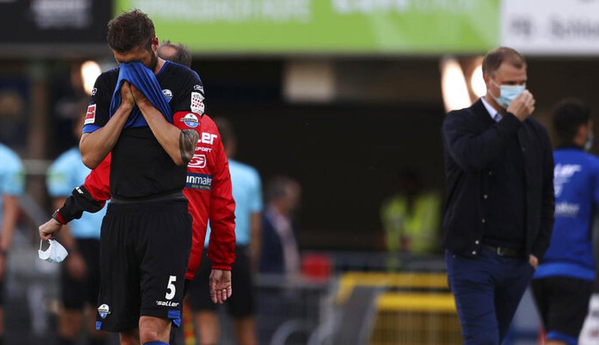 Pemain SC Paderborn 07, Christian Strohdiek, tampak sedih usai ditaklukkan Borussia Dortmund pada laga Bundesliga di Stadion Benteler, Minggu (31/5/2020). Borussia Dortmund menang dengan skor 6-1 SC Paderborn 07. (AP/Lars Baron)
