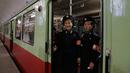 Dua petugas berdiri di pintu kereta yang tengah berhenti di stasiun kereta bawah tanah di Pyongyang, 13 September 2018. Untuk interior gerbong, kereta menampilkan interior kayu. (AP Photo/Kin Cheung)
