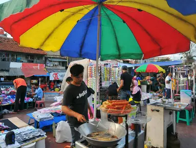 Pedagang menggoreng sosis saat berlangsungnya pasar malam di Petamburan, Jakarta, Selasa (10/1). Pasar malam menjadi alternatif belanja golongan menengah ke bawah. (Liputan6.com/Angga Yuniar)