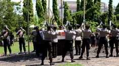 Petugas melepas tembakan salvo ke udara saat upacara pemakaman anggota Polsek Kuta, Aipda I Wayan Sudarsa di Jimbaran, Bali, Minggu (21/8). Prosesi secara institusi Polri itu dilakukan sebelum jenazah dibakar sesuai adat Hindu. (SONNY Tumbelaka/AFP)