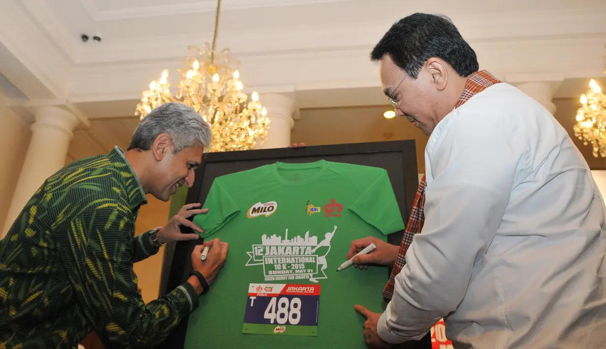 Gubernur Provinsi DKI, Jakarta Basuki Tjahaja Purnama (Kanan) bersama Presiden Direktur Nestle Indonesia, Rashid Qureshi menandatangani kaos peserta Jakarta International 10 K di balai Kota, Jakarta, Jumat (22/05/2015). (Liputan6.com/Herman Zakharia)