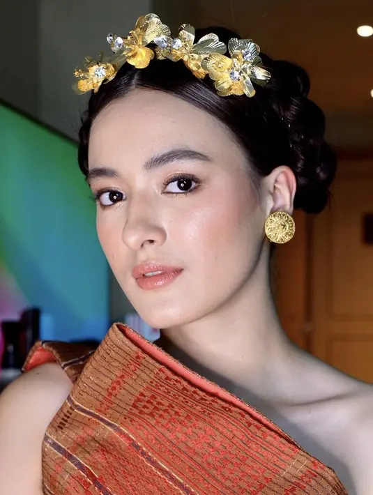 Untuk gaya rambut, Mawar menyanggul rambutnya dengan gaya kepang. Dihiasi dengan bando keemasan model bunga.  [@philipekarunia]