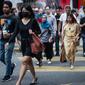 Seorang wanita mengenakan masker di tengah kekhawatiran akan penyebaran virus corona COVID-19, di Kuala Lumpur, Malaysia, Kamis, (13/2/2020). Total kematian akibat virus tersebut di Provinsi Hubei hingga Rabu (12/2) mencapai 1.310 orang. (AFP/Mohd Rasfan)