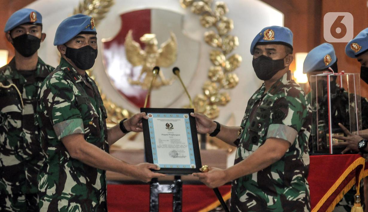 Marsekal Pertama (Marsma) TNI Wahyu Hidayat Sudjatmiko menerima piagam penghgaraan dari Mayjen Tri Budi Utomo saat serah terima jabatan Komandan Pasukan Pengamanan Presiden (Danpaspampres) di Mako Paspampres, Jakarta Pusat, Senin (18/7/2022). Marsma TNI Wahyu Hidayat Sudjatmiko resmi menjabat sebagai Danpaspampres menggantikan Mayjen Tri Budi Utomo. (merdeka.com/Iqbal S. Nugroho)