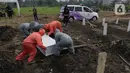 Petugas melakukan pemakaman jenazah dengan protokol Covid-19 di TPU Srengseng Sawah Dua, Jakarta, Kamis (18/3/2021). Dinkes DKI Jakarta mencatat penambahan kasus kematian akibat Covid-19 pada Maret 2021 berada diatas 40 atau meningkat dari 1,6 menjadi 1,7 persen. (Liputan6.com/Helmi Fithriansyah)