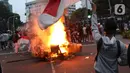 Seorang anak muda mengibarkan bendera Merah Putih di kawasan Gondangdia, Jakarta, Kamis (8/10/2020). Aksi anarkis massa dilakukan saat berunjuk rasa menentang disahkan Omnibus Law UU Cipta Kerja. (Liputan6.com/Helmi Fithriansyah)