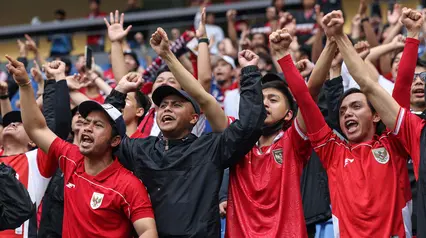 Para suporter Timnas Indonesia memberikan dukungan kepada timnya dalam laga terakhir Grup C Putaran Ketiga Kualifikasi Piala Dunia 2026 melawan Jepang di Suita Stadium, Jepang, Selasa (10/06/2025). (AFP/Paul Miller)