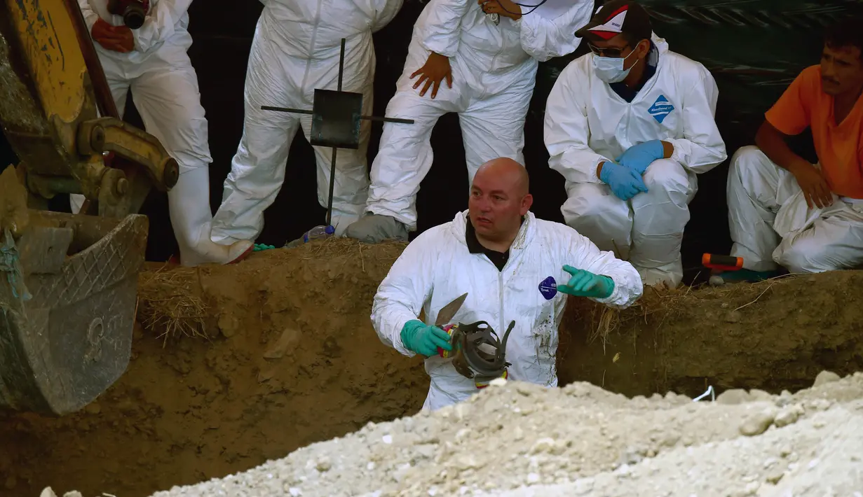 Petugas forensik saat melakukan penggalian kuburan massal di Tetelzingo, Morelos, Meksiko (23/5).Terdapat sedikitnya 116 mayat yang terkubur massal ditempat ini. (ALFREDO ESTRELLA / AFP)