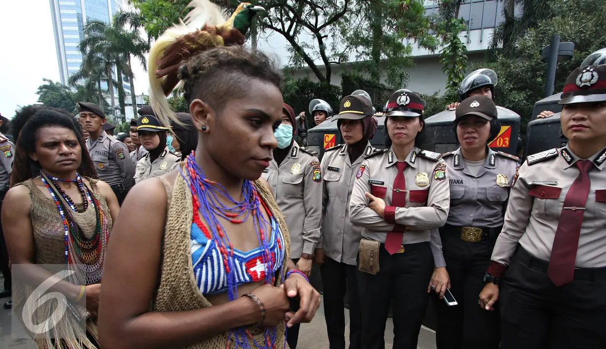 Mahasiswa wanita Papua menyerahkan diri saat berunjuk rasa di kawasan Bunderan HI, Jakarta, Selasa (1/12). Massa menyerahkan diri sebagai bentuk solidaritas usai puluhan lainnya diamankan petugas pascabentrok. (Liputan6.com/Immanuel Antonius)