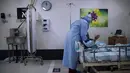 Seorang petugas medis dengan alat pelindung diri merawat pasien COVID-19 di bangsal perawatan di Rumah Sakit Rambam, utara kota Haifa, Israel, Selasa (15/12/2020). Rumah sakit itu mengubah tempat parkir bawah tanah menjadi bangsal perawatan pasien terinfeksi virus corona. (AP Photo/Oded Balilty)