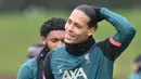 Bek Liverpool, Virgil van Dijk bereaksi selama sesi latihan di tempat latihan Liverpool FC di Liverpool, Inggris (4/4/2022). Liverpool akan bertanding melawan Benfica pada leg pertama perempat final Liga Champions di Estadio Da Luz, Portugal. (AFP/Paul Ellis)