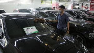 Pekerja membersihkan mobil yang dijual di Showroom Belanja Mobil, Jakarta, Senin (6/2/2023). Guna menghadirkan kebutuhan mobil bekas untuk masyarakat Indonesia saat ini, sejumlah showroom mobil bekas menerapkan penjualan konvensional serta penggunaan platform media sosial yang bisa memudahkan transaksi pembelian dan penjualan kendaraan. (Liputan6.com/Faizal Fanani)