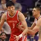 Pebasket Houston Rockets, Zhou Qi, berusaha melewati pebasket Phoenix Suns pada laga NBA di Arizona, AS, Minggu (16/11/2017). (AFP/Christian Petersen)