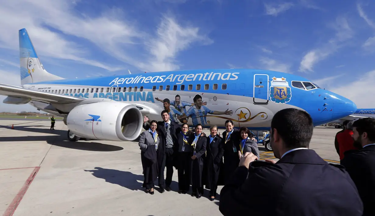 Beberapa kru berpose di depan pesawat yang didominasi warna kostum Timnas Argentina Biru-Putih di Bandara Ezeiza di Buenos Aires, Argentina, (3/6/2014). (REUTERS/Marcos Brindicci)