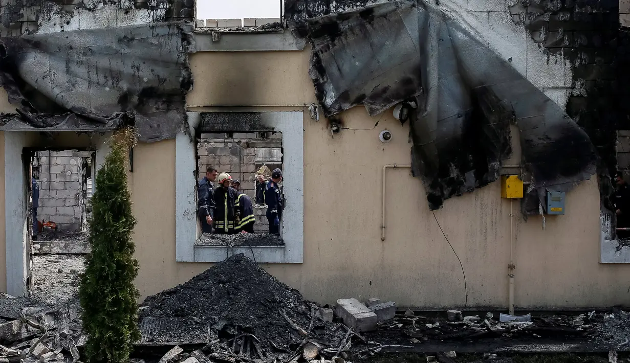 Pemadam kebakaran berada di bangunan perumahan yang menampung kelompok usia lanjut di sebuah desa dekat Kiev, Ukraina, Minggu (29/5). Sedikitnya 17 orang tewas setelah api menghanguskan bangunan yang dihuni oleh 35 orang tersebut. (REUTERS/Gleb Garanich)