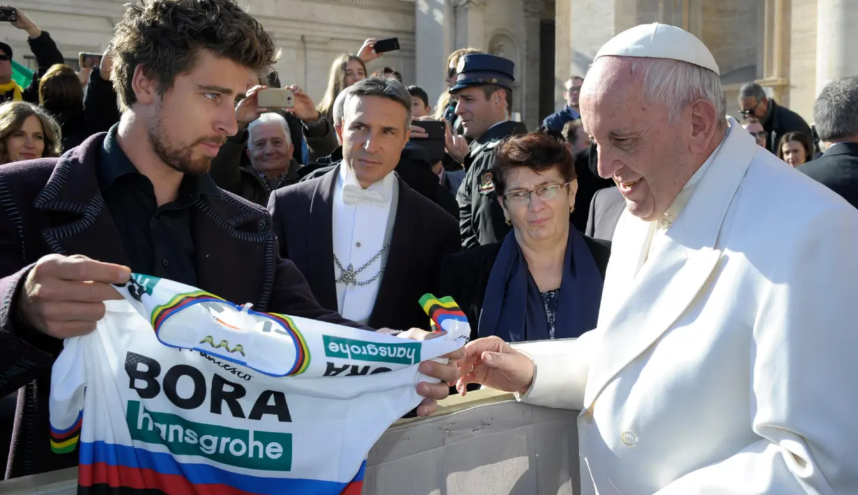 Juara sepeda Slovakia Peter Sagan menawarkan jersey yang dipakai saat menjadi juara dunia kepada Paus Fransiskus pada akhir audiensi mingguan di Vatikan (24/1). (AFP/HO/Osservatore Romano)