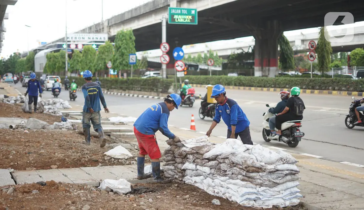 Petugas mengumpulkan sampah dan lumpur di saluran gorong-gorong air di Jalan DI Panjaitan, Kebon Nanas, Jakarta, Jumat (6/12/2019). Hal tersebut dilakukan guna mengantisipasi tersumbatnya saluran air selama memasuki periode musim hujan. (Liputan6.com/Immanuel Antonius)