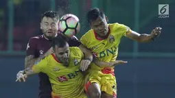 Gelandang PSM Makassar, Marc Anthony Klok (kiri) berebut bola atas dengan dua pemain Bhayangkara FC pada lanjutan Liga 1 Indonesia di Stadion Patriot Candrabhaga, Bekasi, Kamis (19/10). PSM Makassar unggul 2-0. (Liputan6.com/Helmi Fithriansyah)