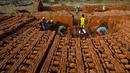 Pekerja India bekerja di sebuah tempat pembakaran batu bata di pinggiran Gauhati, India (22/11). Sebagian besar buruh di sini mendapatkan Rupee 120 (kurang dari 2 Dolar) per hari. (AP Photo/Anupam Nath)