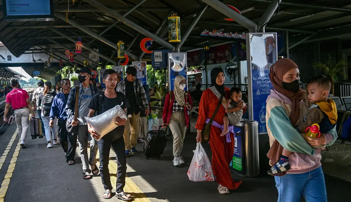 Para penumpang keluar dari stasiun kereta api setibanya mereka di Surabaya, Jawa Timur pada 6 April 2025. (JUNI KRISWANTO/AFP)