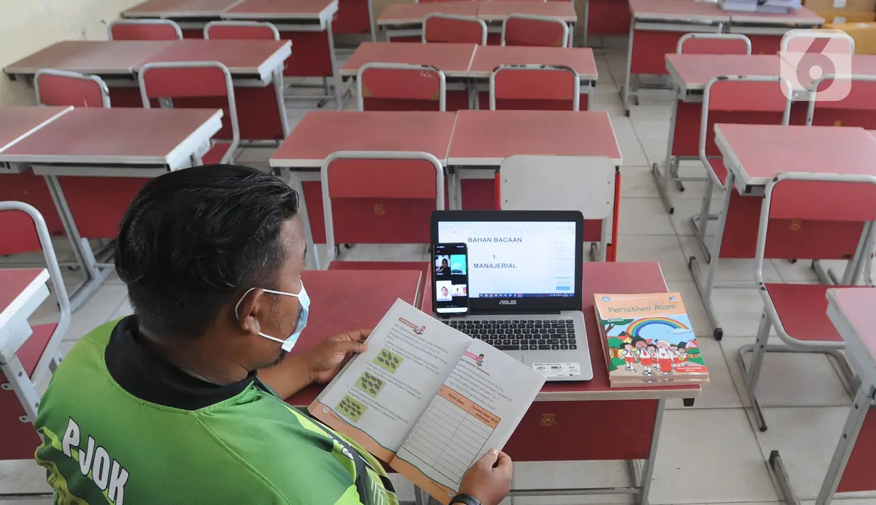 Guru mengajar mata pelajaran olah raga secara darling pada sebuah kelas kosong di SDN Pondok Cabe Udik 01, Pamulang, Tangerang Selatan, Jumat (8/1/2020). Rencana kegiatan belajar tatap muka pada awal Januari di wilayah Tangsel dibatalkan. (merdeka.com/Arie Basuki)