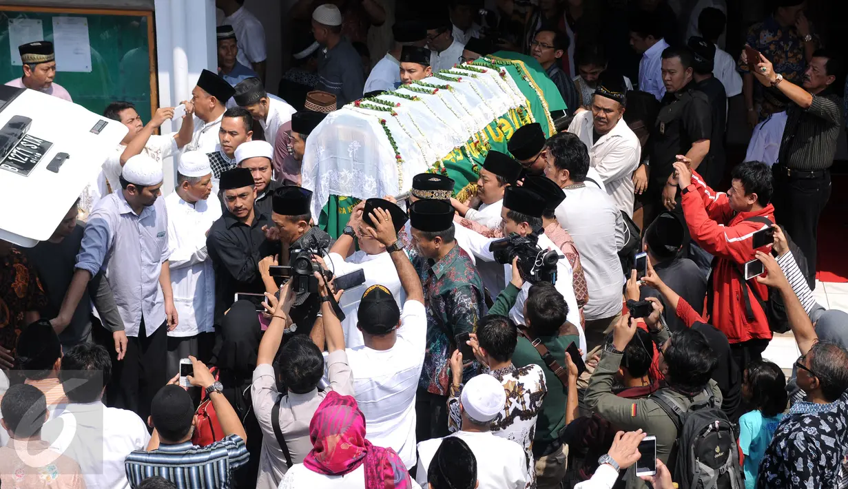 Sejumlah pelayat menggotong jenazah Ketua KPU Husni Kamil Manik usai disalatkan di Kompleks KPU, Jakarta, Jumat (8/7). Husni Kamil Manik wafat diusia 40 tahun pada Kamis malam (7/7). (Liputan6.com/Helmi Fithriansyah)