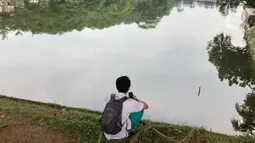 Warga beraktivitas di sekitar Setu Cibinong, Jawa Barat, Kamis (11/6/2020). Meskipun spanduk larangan penutupan telah dipasang, namun sebagian warga tetap nekat beraktivitas di kawasan tersebut untuk memancing ikan atau berekreasi. (Liputan6.com/Immanuel Antonius)