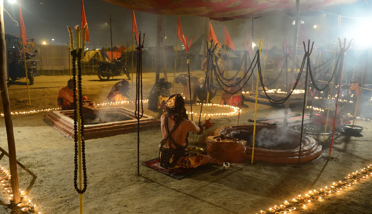 Umat Hindu India melakukan ritual keagamaan saat acara tradisional Magh Mela di Sangam, India (2/1). Dalam acara ini selama sekitar satu bulan, ribuan peziarah dan para Sadhu (orang suci umat Hindu) melakukan ritual. (AFP Photo/Sanjay Kanojia)