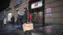 Seorang pria membawa kantong belanja setelah meninggalkan toko utama H&M di Moskow, Rusia, Rabu (30/11/2022). Pengecer mode no.2 dunia itu akhirnya menutup semua tokonya di Rusia untuk selamanya. (AP Photo/Alexander Zemlianichenko)