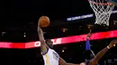 Pebasket Golden State Warriors Harrison Barnes melakukan Dunk saat dibayangi pebasket Detroit Pistons Reggie Jackson di ORACLE Arena, California, Senin (9/11/2015). Warriors menang 109-95. (Getty Images/AFP/Ezra Shaw)