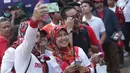 Calon penonton seremoni pembukaan Asian Games 2018 berswafoto jelang masuk kawasan GBK, Jakarta, Sabtu (18/8). Asian Games 2018 akan berlangsung hingga 2 September, mendatang. (Liputan6.com/Helmi Fithriansyah)