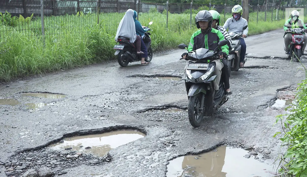 Pengendara sepeda motor berusaha menghindari jalan yang rusak di Jalan Raya Gas Alam, Depok, Jawa Barat, Selasa (7/5). Kondisi jalan yang tidak kunjung diperbaiki tersebut menjadi kubangan air setiap hujan serta berbahaya bagi keselamatan pengguna jalan. (Liputan6.com/Immanuel Antonius)