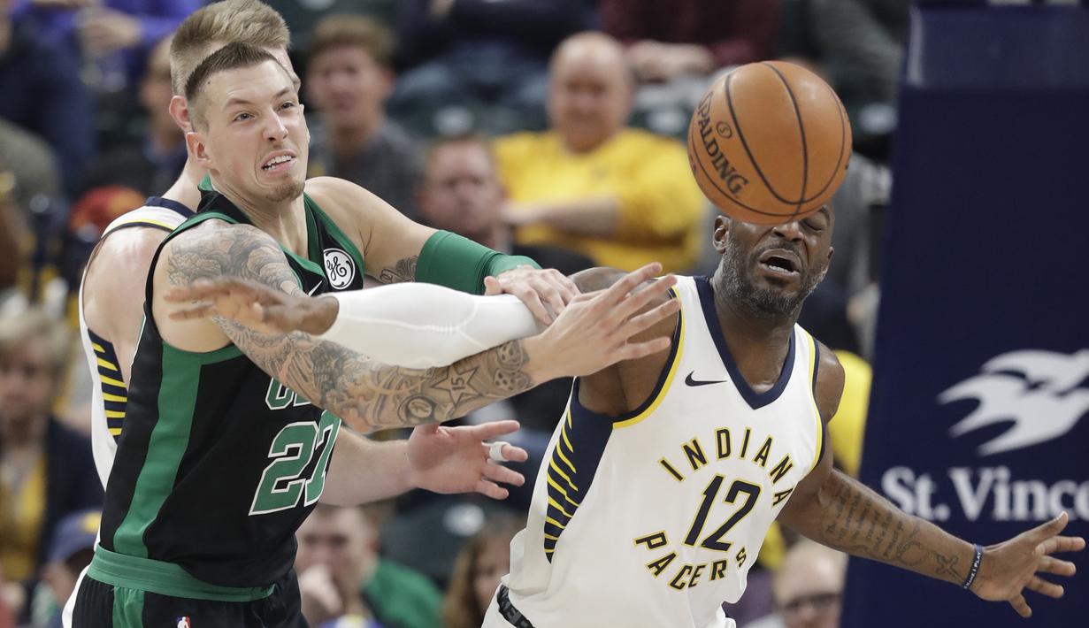 Pemain Boston Celtics, Daniel Theis (tengah) berebut bola dengan pemain Indiana Pacers, Damien Wilkins (kanan) pada lanjutan NBA basketball game di Bankers Life Fieldhouse, Indianapolis, (25/11/2017). Boston Celtics menang 108-98. (AP/Darron Cummings)