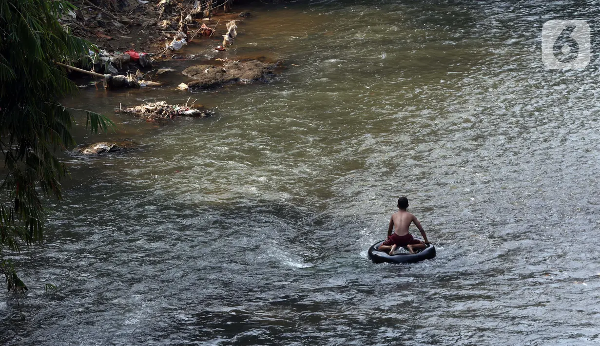 Seorang anak bermain di aliran Sungai Ciliwung, Kota Depok, Jawa Barat, Senin (27/7/2020). Setiap tanggal 27 Juli diperingati sebagai Hari Sungai Nasional, namun ironisnya kondisi sungai Ciliwung masih terlihat banyak ceceran sampah, terutama plastik. (Liputan6.com/Helmi Fithriansyah)