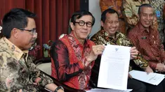 Menkumham Yasonna Laoly (kedua kiri) menunjukan surat pengaktifan kembali kepengurusan Golkar Munas Riau, Jakarta, Kamis (28/1/2016). SK Kepengurusan Partai Golkar Munas Riau diaktifkan untuk 6 bulan ke depan. (Liputan6.com/Johan Tallo)