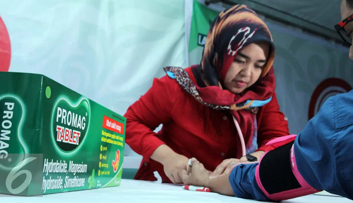Seorang petugas memeriksa seorang warga yang melakukan konsultasi kesehatan gratis di area Masjid Istiqlal, Jakarta, (3/7/2015).  Dalam acara tersebut diluncurkan “Gerakan Jakarta Mengaji”. (Liputan6.com/Helmi Afandi)