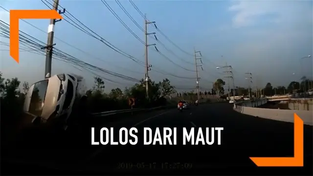 Seorang pengendara motor lolos dari maut setelah tertabrak mobil yang hilang kendali. Mobil sebelumnya menabrak pembatas jalan sebelum menghantam motor.