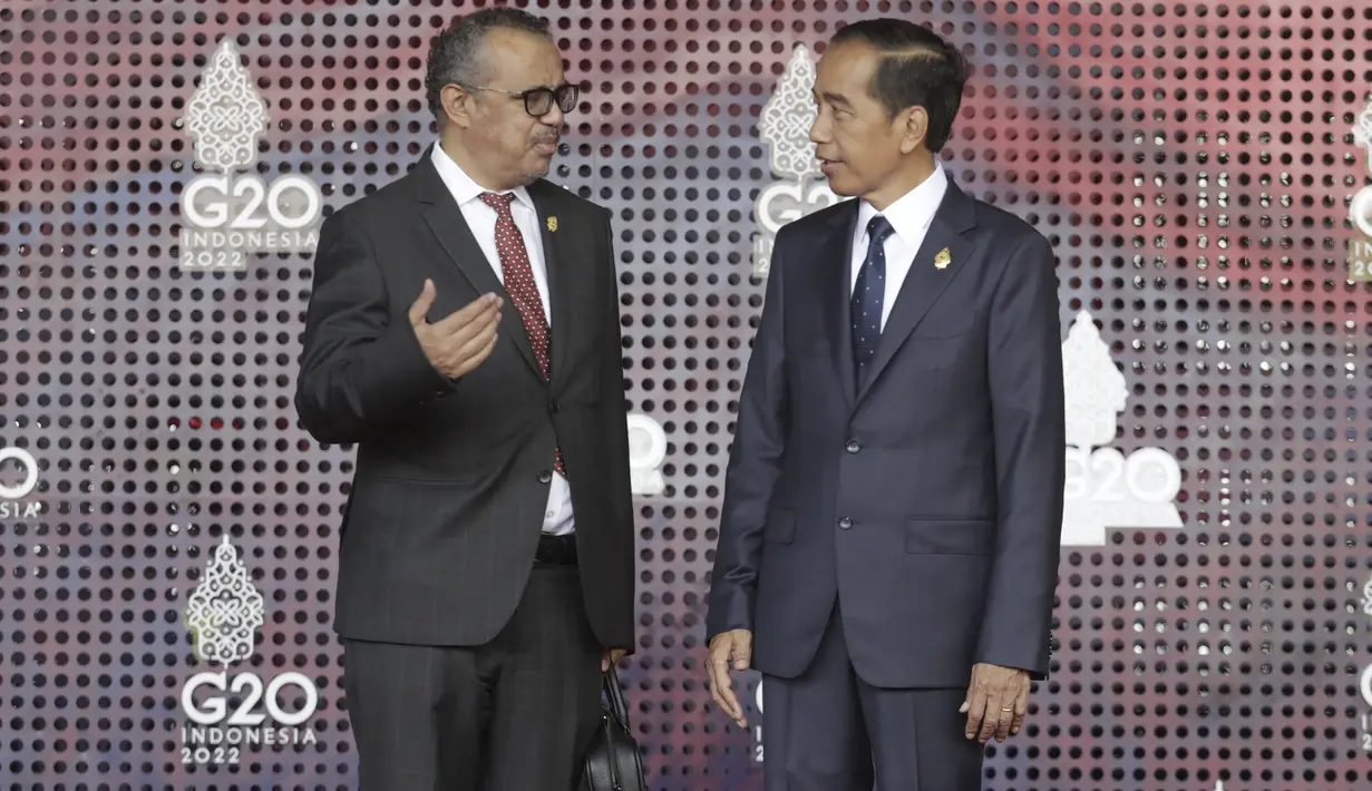 Presiden Indonesia Joko Widodo (kanan) menyapa Direktur Jenderal Organisasi Kesehatan Dunia (WHO) Tedros Adhanom Ghebreyesus di Nusa Dua, Bali, Selasa (15/11/2022) pagi. Selain bersalaman, Jokowi dan para pemimpin itu melakukan sesi foto bersama. (Mast Irham/Pool Photo via AP)