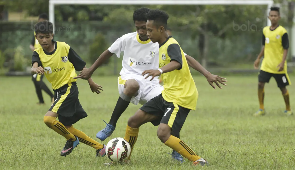 Pemain SSB Galunggung FC berusaha melewati kepungan pemain SSB Tulehu Putra pada semifinal turnamen Liga Remaja UC News di Lapangan Masariku Yonif 733, Ambon, Rabu (29/11/2017). (Bola.com/Peksi Cahyo)