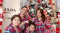 Jessica Iskandar kompak mengenakan piyama kotak-kotak warna merah dengan suami dan ketiga anak-anaknya. Keluarga ini pun berfoto di depan pohon natalnya tahun ini. [@inijedar]