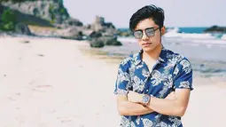 Saat pergi berlibur di pantai, kacamata menjadi fashion item yang tak boleh terlewatkan bagi bintang sinetron ini. Berbusana baju pantai dengan kacamata hitam, membuat penampilan Riza terlihat lebih maskulin. (Liputan6.com/IG/@rizasyah_14)