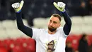 Kiper Paris Saint-Germain (PSG) Gianluigi Donnarumma memberi isyarat saat mengenakan kaos dengan potret mendiang legenda sepak bola Brasil Pele sebelum lanjutan Liga Prancis 2022/2023 melawan Angers di Parc des Princes, Kamis (12/1/2023) dini hari WIB. Para pemain PSG memberikan tribute spesial untuk Edson Arantes do Nascimento atau lebih dikenal sebagai Pele. (Bertrand GUAY / AFP)