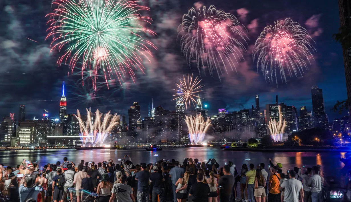 Penonton berkumpul di sepanjang tepi pantai Williamsburg untuk menyaksikan pertunjukan kembang api Macy dengan pemandangan cakrawala Manhattan pada perayaan Hari Kemerdekaan di Brooklyn, New York, Amerika Serikat, 4 Juli 2022. Kembang api meledak dari tongkang di East River. (AP Photo/Bebeto Matthews)